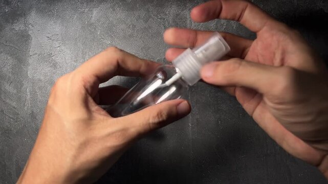 person hands opening clear cosmetic spray bottle container