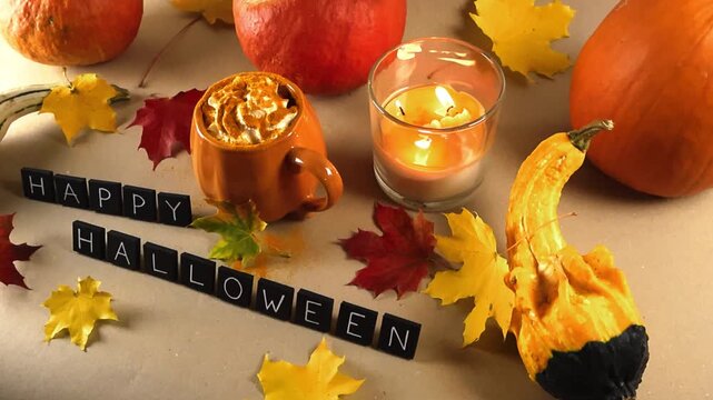 Cozy autumn still life celebrating Halloween with pumpkins, gourds, a burning candle, colorful maple leaves, and a pumpkin spice latte topped with whipped cream and cinnamon
