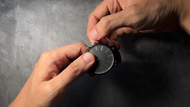 hands opening black round container lid on table
