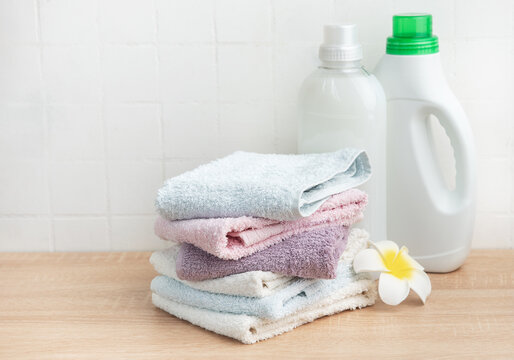Freshly laundered towels stacked with cleaning products