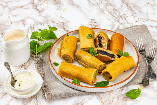 Rolled pancakes with poppy seed filling on plate