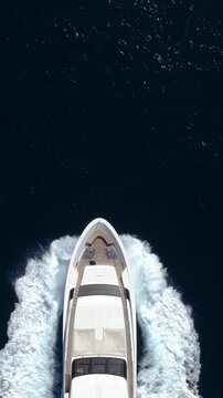 Aerial overhead view of a bow of a luxury yacht sailing with high speed over the ocean