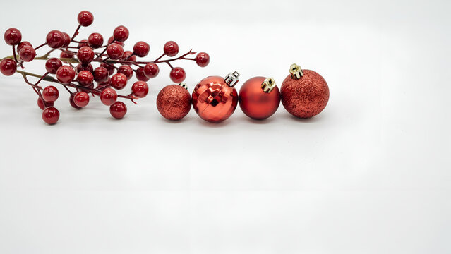 Red christmas ornaments and holly berries isolated on white background