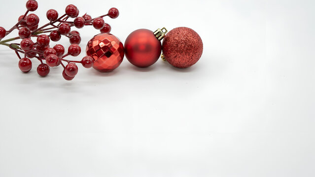 Red christmas ornaments and holly berries isolated on white background