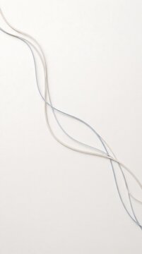 Silver metallic threads forming elegant curves against plain background