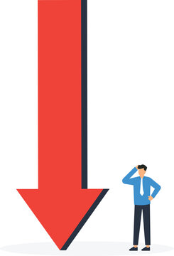 A businessman standing next to a massive red downward arrow representing financial loss and business crisis.