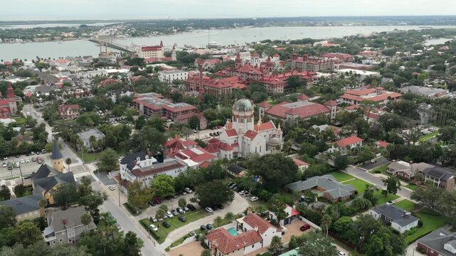 Aerial view of the historic Memorial Presbyterian Church surrounded by lush trees and red-roofed buildings in St. Augustine, Florida, United States.