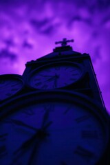 Fototapeta premium Silhouette of a historic clock tower against a dramatic purple twilight sky.