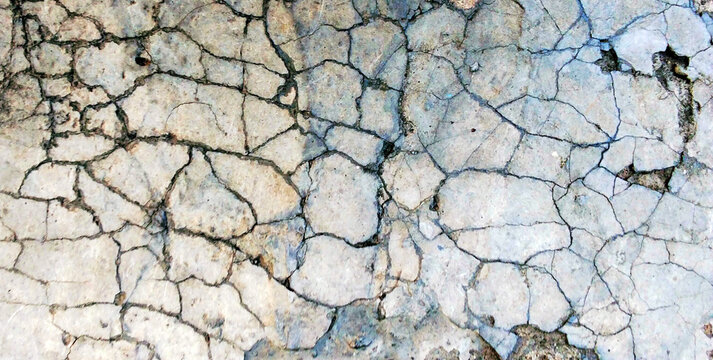 A stone surface with a cracked and severely fractured texture.
