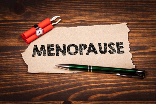 MENOPAUSE Message With Dynamite Timer and Pen on Rustic Wooden Desk