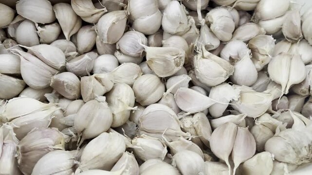 Wholesale organic garlic cloves pile inside a brown cardboard box