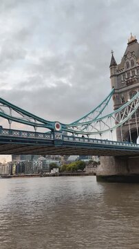 Tower Bridge viewed from River Thames under cloudy London sky