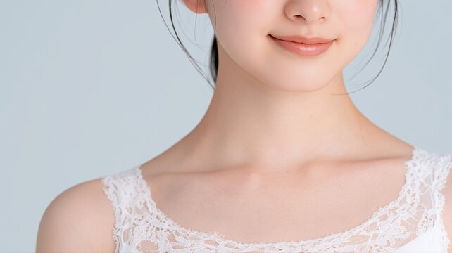 女性の口元と鎖骨がアップで写っている。ナチュラルな肌の質感を活かした美容やスキンケアのイメージ素材