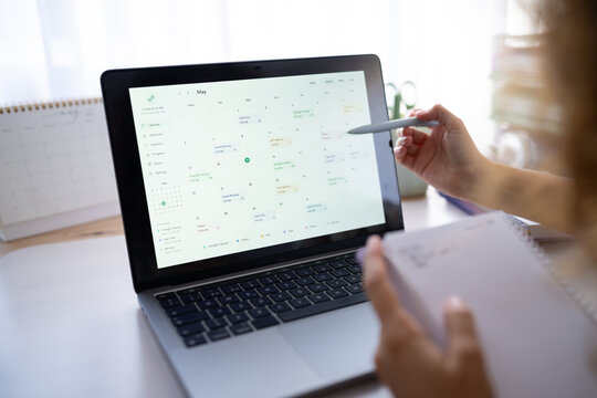 Calendar on laptop screen with white woman planning workouts