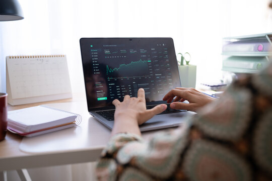 Stock market analysis on laptop in home office setting