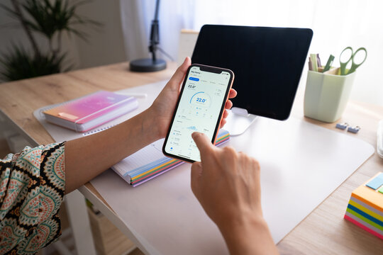 White person smartphone checking app screen at desk in home office