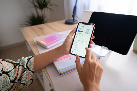 White woman using smartphone with digital health app in home office
