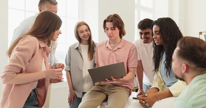 Students group with laptop in university classroom discussion. Peers collaborate on a project, practicing teamwork and learning in space for education. Team study group concept presented.