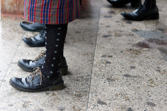 Low section of people in shoes on a tiled floor, Thimphu, Bhutan