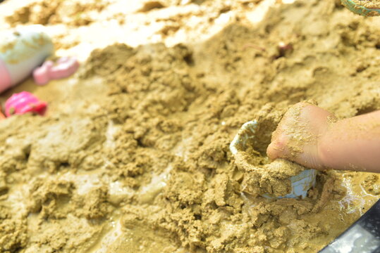 Child's hand playing in mud with space for text