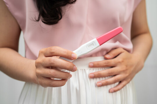 Asian holding pregnancy test for female of ovulation day, fetus, maternity, childbirth, birth control.