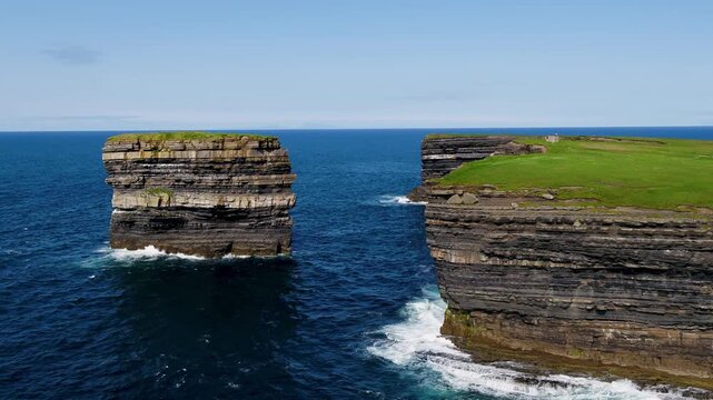 Aerial view of Dun Briste sea stack rising from the Atlantic Ocean near the rugged cliffs of Ballycastle, County Mayo, Ireland.