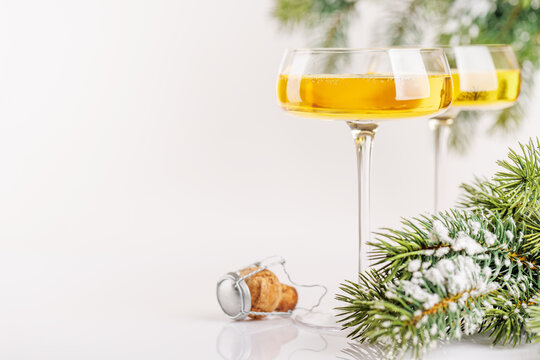 Champagne glasses and snowy fir on white