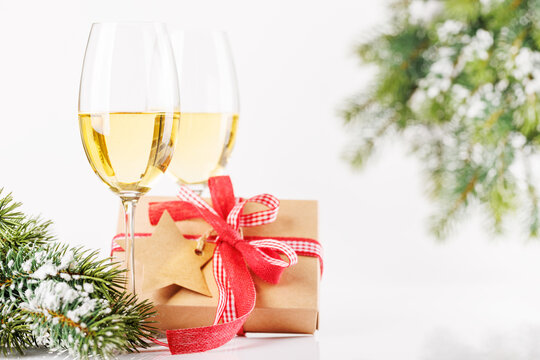 Champagne glasses and snowy fir on white