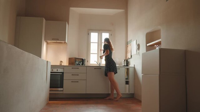 Young smiling couple enjoying a warm morning coffee together in a bright, modern kitchen, talking and bonding over a hot beverage at home while enjoying a peaceful moment