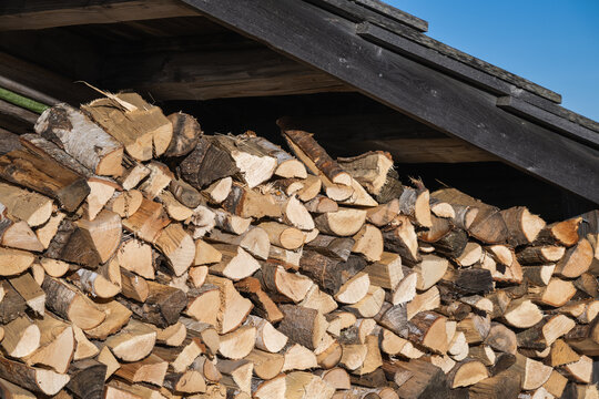 Firewood supplies for the winter stacked under the overhang of a hut