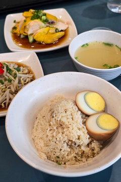Hainanese Chicken Rice Set Served with Braised Egg, Bean Sprouts, and Soup.
