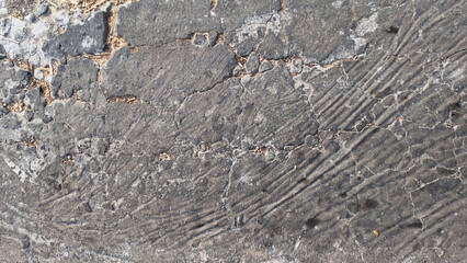 Rough Natural Stone Surface with Weathered Gray Rock Texture. Close-up of a rough weathered gray natural stone surface with irregular geological patterns, mineral textures, cracks, and rugged details.