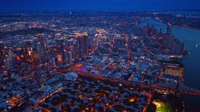 Luminous lights of modern New York City at night. Slow movement over the night city scenery from drone.
