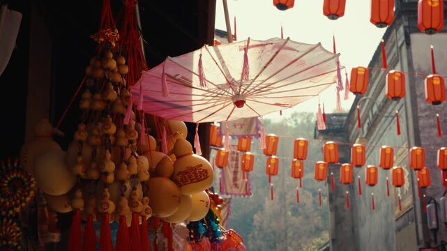 Traditional Chinese parasol and ornaments beneath rows of red lanterns.