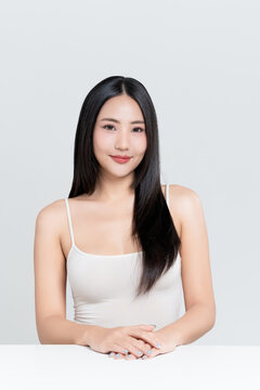 Happy young Asian woman with beauty face natural makeup and healthy black hair isolated on white background, for a perfectly woman, self care, cosmetics and wellness concept.