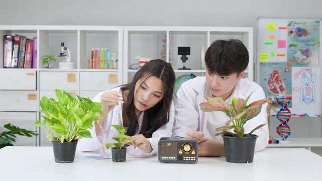 Teenage Students in Lab Coats Measuring Plants During Science Experiment