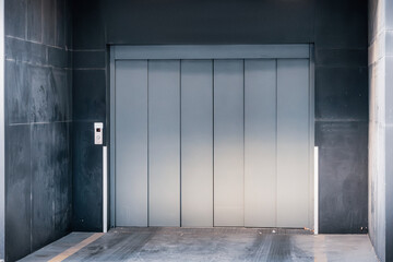 Metal cargo elevator in an industrial warehouse or parking facility, providing vertical transport for logistics and heavy goods © EdNurg