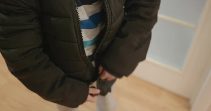 Close-up children's hands zipping zip jacket. 4K 10-bit