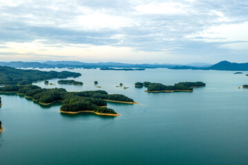 Aerial view of thousand islands on the emerald lake surface with green mountains © zhangyang135769