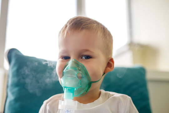 Cute little kid boy wear use medical nebulizer mask inhaling steam respiratory therapy lungs rsv allergic disease cure. Portrait child treating seasonal respiratory bronchitis cough medical inhaler