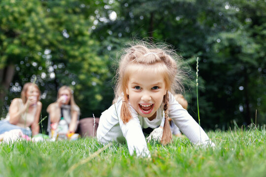 Portrait two cute little kids boy girl enjoy having fun  lying green grass garden park meadow family mother on summer sunny day. Children carefree joy walk with mom yard. Happy childhood healthcare