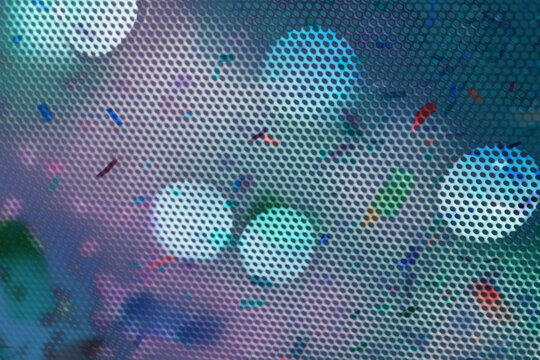 Abstract mesh pattern with cyan and purple bokeh lights and confetti specks. Dynamic, futuristic texture with depth. Ideal background for modern tech and event design.