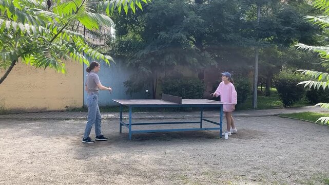 Outdoor sport - two Women Engage In Lively Table Tennis Game