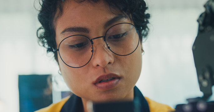 Close-up young Black female engineer coding AI robot arm in modern laboratory. Robotics, artificial intelligence, technology, stem, future, innovation, diversity, automation, machine learning concept.