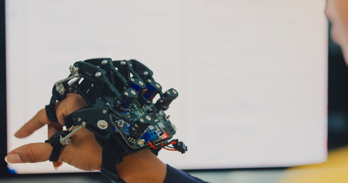 Close-up young Black female engineer coding AI robot arm in modern laboratory. Robotics, artificial intelligence, technology, stem, future, innovation, diversity, automation, machine learning concept.
