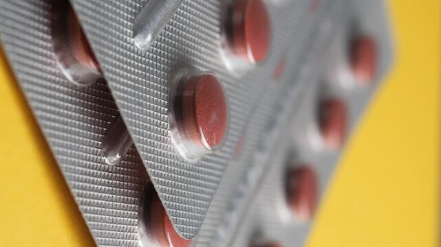 Close up of red medical pills in blister packs, healthcare and medicine concept, pharmaceutical packaging footage.