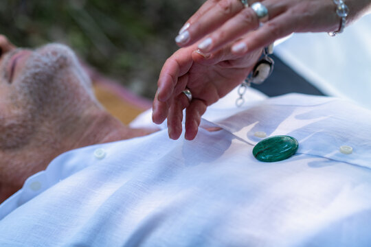 Healing crystal resting over the heart area while a practitioner performs gentle energy work, symbolizing spiritual connection, emotional balance, and mindful healing.