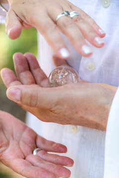 Clear crystal held between open hands during an energy healing practice, symbolizing spiritual connection, mindful awareness, energetic balance, and holistic wellness.