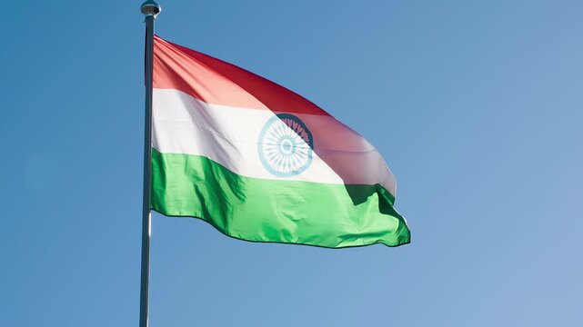 Indian Flag Lit by the Sun. The Big State Flag is illuminated by the sun and flutters epically in the wind against the blue sky