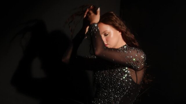 Cinematic film still concept, woman in a crystal gown with light rays. Hand near the head, hard shadow and prismatic beams build a noir style scene.